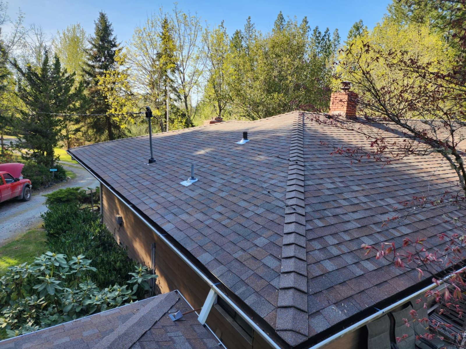 Composite shingle roof installation on a residential home in Southern Oregon with clean ridge lines and new vent flashing